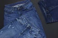 Set of men`s and women`s blue jeans on black background top view flat lay. Detail of nice blue jeans. Jeans texture or denim Royalty Free Stock Photo