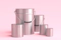 Set of metal cans or buckets of paint with handle on pink background.