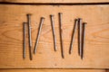 Set of metalware, rusty nails on the wooden background Royalty Free Stock Photo