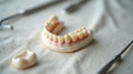 Detailed dentures and dental tools on a soft white cloth background Royalty Free Stock Photo