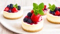 Set of mini Cheesecake with red berries syrup, fresh berries and mint, on light background. Birthday cake, a sweet dessert