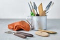 A set of modeling tools in a metal mug and a piece of brown plasticine on a gray stone table. Sculptors workshop a place Royalty Free Stock Photo