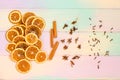 Set for mulled wine on rainbow background, scattered dry oranges, cinnamon, cloves, star anise, with copyspace