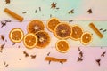 Set for mulled wine on rainbow background, scattered dry oranges, cinnamon, cloves, star anise, with copyspace