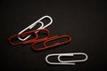 A set of multi-colored office paper clips of plastic are scattered on black monophonic background. Royalty Free Stock Photo