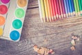 Creativity: Multi-colored pencils, water colors and brushes on rusty wooden table Royalty Free Stock Photo