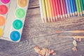 Creativity: Multi-colored pencils, water colors and brushes on rusty wooden table Royalty Free Stock Photo