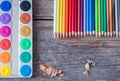 Creativity: Multi-colored pencils, water colors and brushes on rusty wooden table Royalty Free Stock Photo