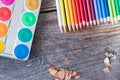 Creativity: Multi-colored pencils, water colors and brushes on rusty wooden table Royalty Free Stock Photo