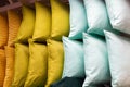 A set of multi-colored pillows in limbo in a supermarket.
