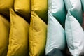 A set of multi-colored pillows in limbo in a supermarket.