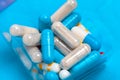Set of multi-colored tablets and capsules on a blue background Royalty Free Stock Photo