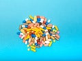 Set of multi-colored tablets and capsules on a blue background Royalty Free Stock Photo