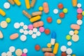 Set of multi-colored tablets and capsules on a blue background Royalty Free Stock Photo