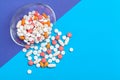 Set of multi-colored tablets and capsules on a blue background Royalty Free Stock Photo