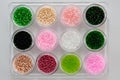 Set of multicolored beads for embroidery and needlework in plastic jars Royalty Free Stock Photo