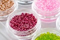 Set of multicolored beads for embroidery and needlework in plastic jars Royalty Free Stock Photo