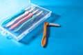 Set of multicolored female razors in a plastic box. On a blue background Royalty Free Stock Photo