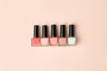 Set of nail polish bottles neutral natural colors on beige background. Concept of pallete for french manicure, woman beauty Royalty Free Stock Photo