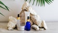 Set natural beauty cosmetic skincare products with palm leaf plant on stone pedestal, rock pile balancing stones gray