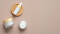 Set of natural cosmetic products on beige background. Flat lay serum dropper bottle and moisturizer cream jars. Organic beauty