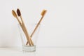 Set of natural toothbrushes in glass on table in bathroom