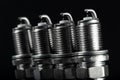 A set of new spark plugs of the car, and spare parts of vehicles on a dark background Royalty Free Stock Photo