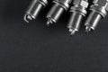 A set of new spark plugs of the car, and spare parts of vehicles on a dark background Royalty Free Stock Photo