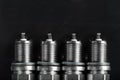 A set of new spark plugs of the car, and spare parts of vehicles on a dark background Royalty Free Stock Photo