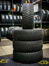 Set of new winter tires with studs, tire shop in the background