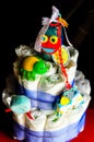 Set of newborn baby things - cake made from diapers on dark background Royalty Free Stock Photo