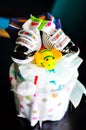 Set of newborn baby things - cake made from diapers on dark background Royalty Free Stock Photo