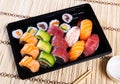 Set of nigiri sushi, uramaki and norimaki rolls in plastic tray
