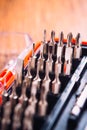 Set of nozzles for screwdriver in red box on wooden background Royalty Free Stock Photo