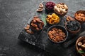 Set of nuts and dried fruits and berries on a black stone background. Top view. Royalty Free Stock Photo