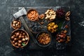 Set of nuts and dried fruits and berries on a black stone background. Top view. Royalty Free Stock Photo