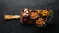 Set of nuts and dried fruits and berries on a black stone background. Top view. Royalty Free Stock Photo