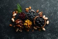 Set of nuts and dried fruits and berries on a black stone background. Top view. Royalty Free Stock Photo