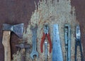 Set of old construction tools: hammer, saw, pliers, etc. on a flat lay background of rusty metal.