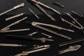 Set of old different compasses. Retro metal compasses and drafting tools on a black background. Drawing pen. Royalty Free Stock Photo