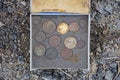 Set of old dirty coins lie in a square gray box