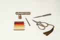 A set of old style copper scissors, thimbles and sewing accessories along with spools of multi colored thread on a plain white