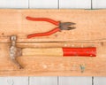 Set of old tools hammer and pliers on wooden background