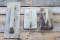 Set of old used trowels on a rough wooden surface Royalty Free Stock Photo