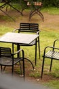A set of one table and three iron chairs placed in the middle of a grass-covered garden Royalty Free Stock Photo