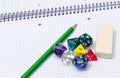 Set of open exercise book, pencil, rubber and dices on Royalty Free Stock Photo