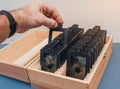 Set of optical lenses in a wooden box. Male hand selects a lens. Optics