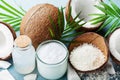 Set of organic coconut products for spa, cosmetic or food ingredients decorated palm leaves. Coconut oil, water and shavings. Royalty Free Stock Photo
