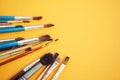 Set of paint brushes on the yellow background