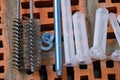 Set of parts for mounting anchors in hollow brick and concrete lie on the surface of the brickwork in any order. Studs threaded, Royalty Free Stock Photo